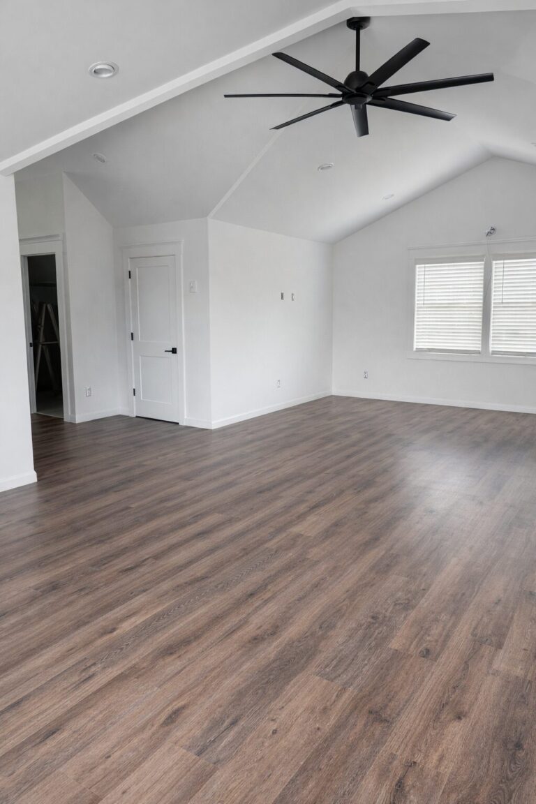 A contemporary master bedroom in Bergen County featuring luxury vinyl plank flooring with a realistic oak wood grain and matte finish, installed by Precision Hardwood Flooring.