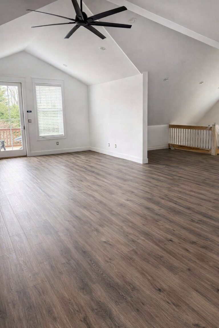 A bright, vaulted second-story room in a Bergen County home featuring high-end Luxury Vinyl Plank (LVP) flooring and a new wooden safety railing, installed by Precision Hardwood Flooring.