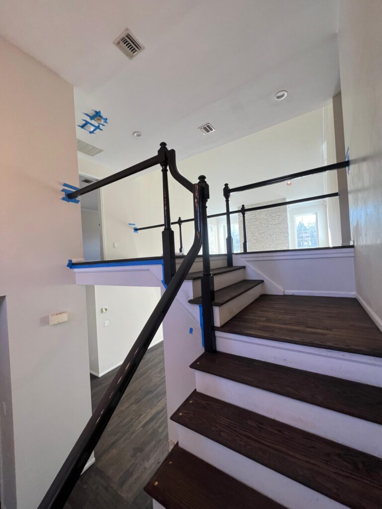 A newly installed hardwood staircase landing in a Bergen County home, featuring natural white oak planks, a matching handrail, and square white balusters by Precision Hardwood Flooring.