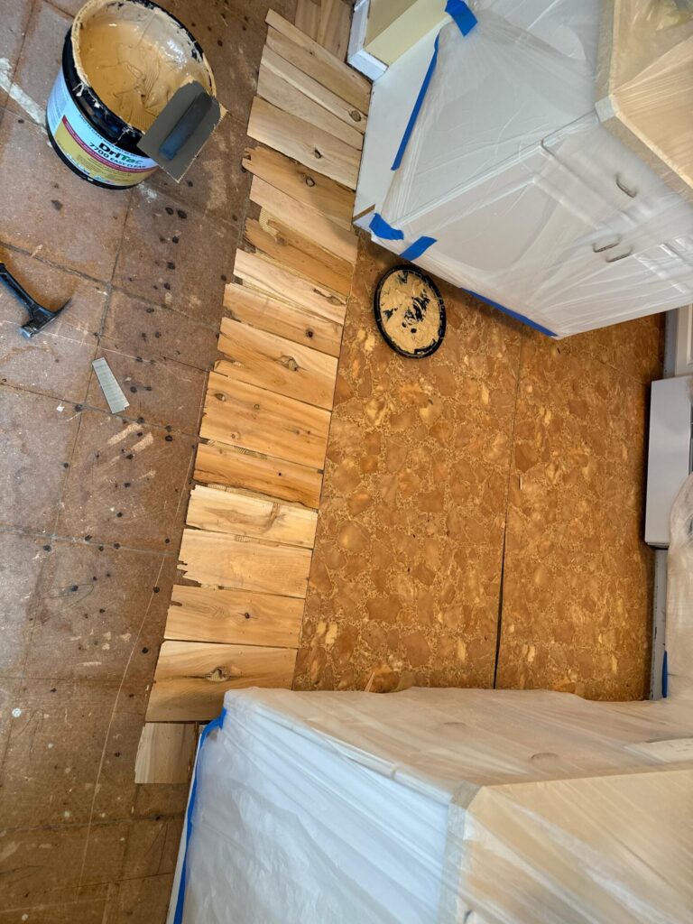 Precision Hardwood Flooring using cedar shims and DriTac flooring adhesive to prep a kitchen subfloor for hardwood installation